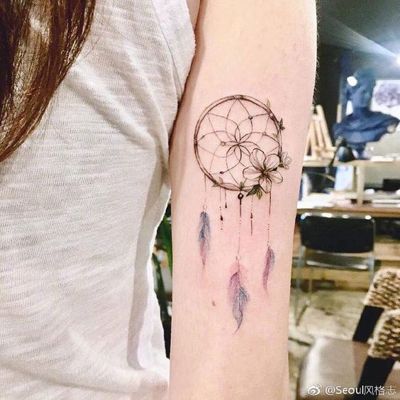  Tatouage attrape rêve avec une belle fleur blanche sur le haut du bras
